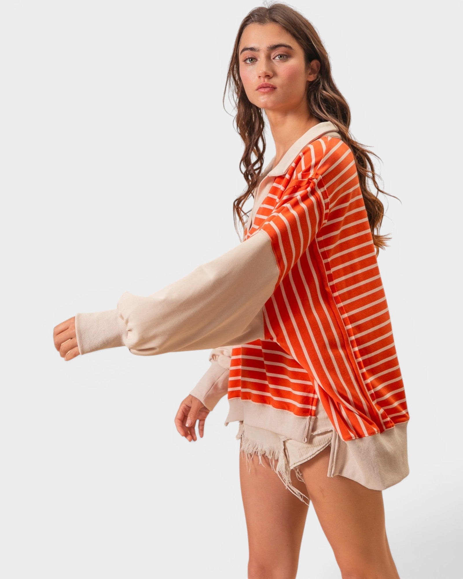 Woman wearing a red and white striped shirt with beige sleeves on a white background