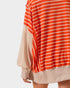 Orange and white striped dress with beige accents on a white background