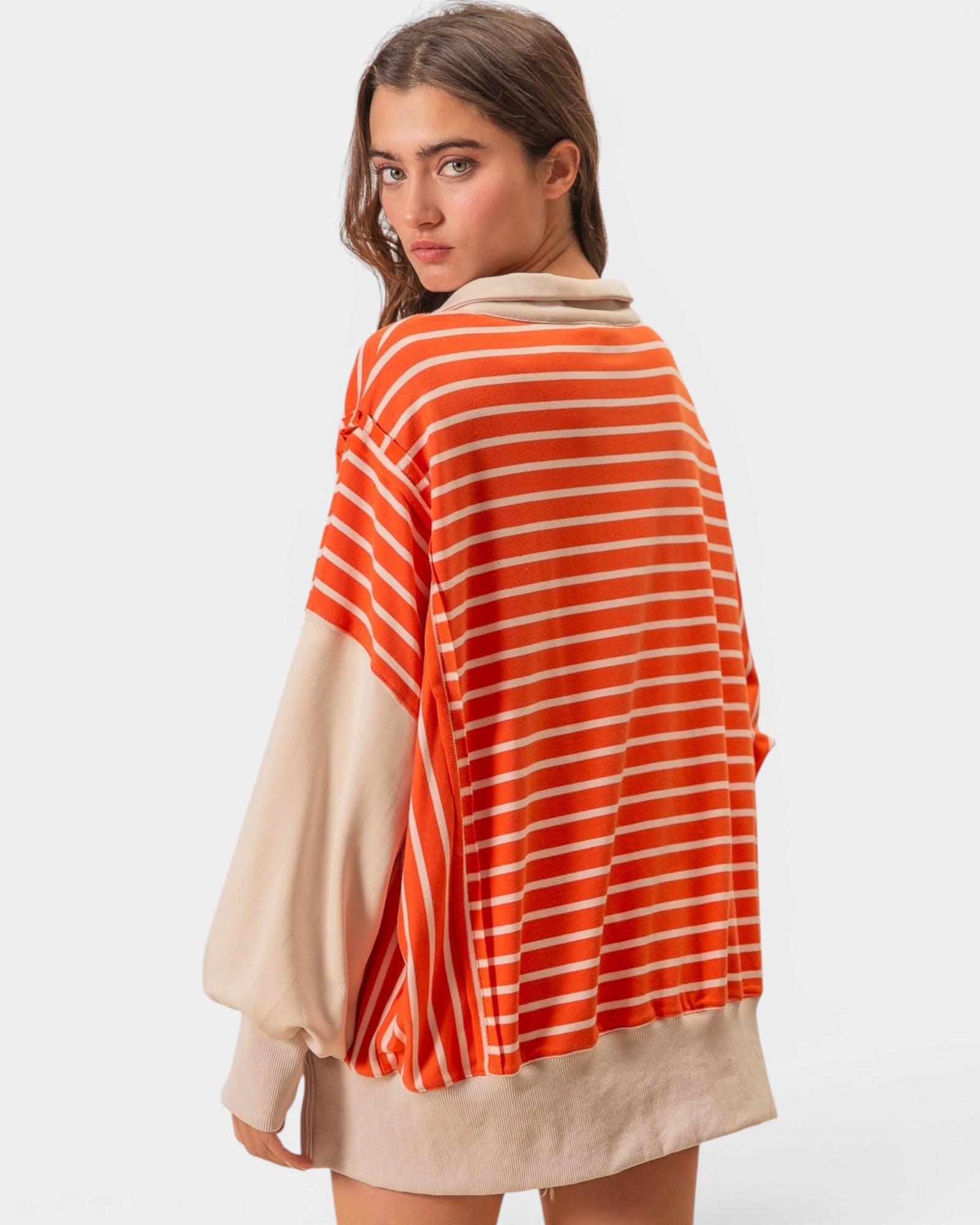 Woman wearing a striped sweater with a plain background