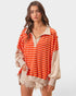 Woman wearing an orange and beige striped shirt with a white background