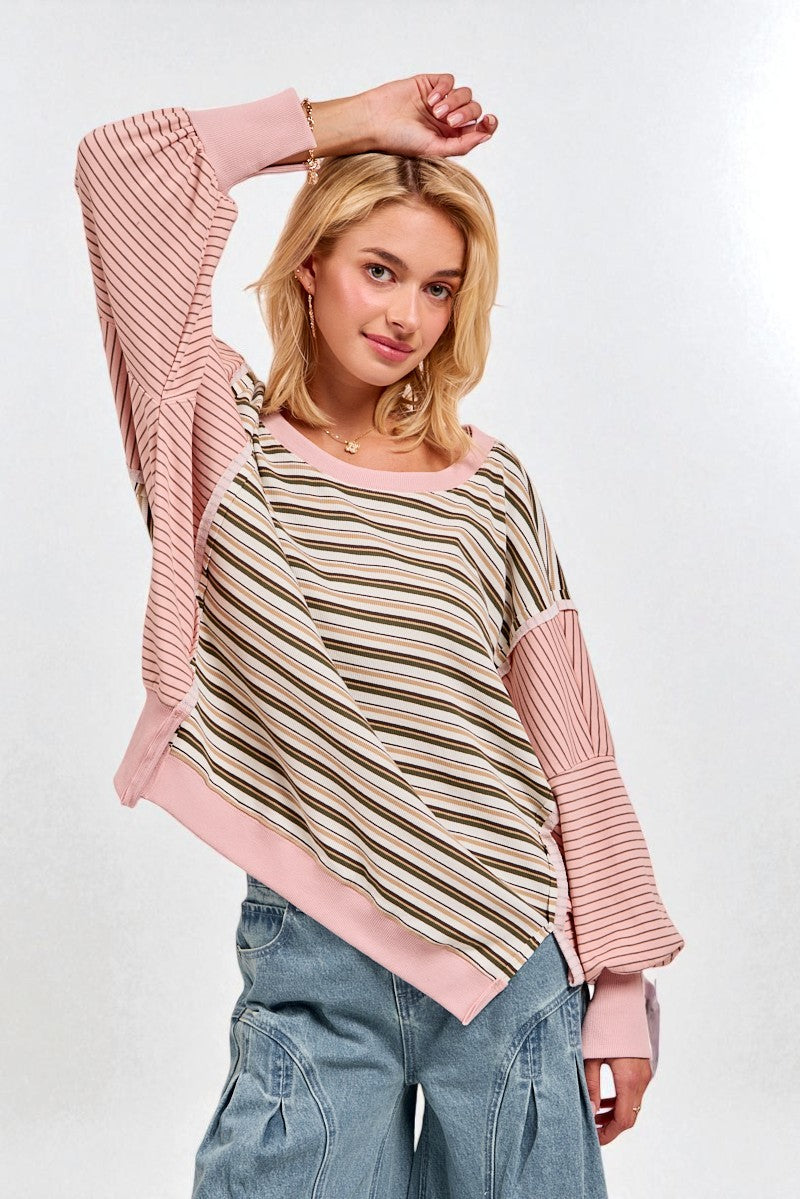 Woman wearing a striped sweater with pink sleeves on a white background