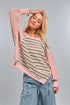 Woman wearing a pink and striped top with a gray background