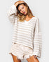 Woman wearing a striped sweater and shorts on a plain background