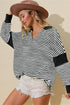 Woman wearing a black and white striped shirt with elbow patches and a brown hat on a beige background