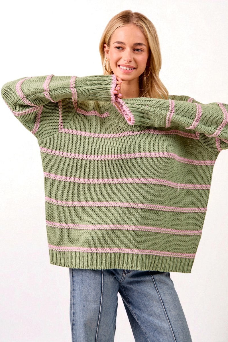 Woman wearing a green and pink striped sweater on a white background