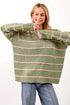 Woman wearing a green and pink striped sweater on a white background