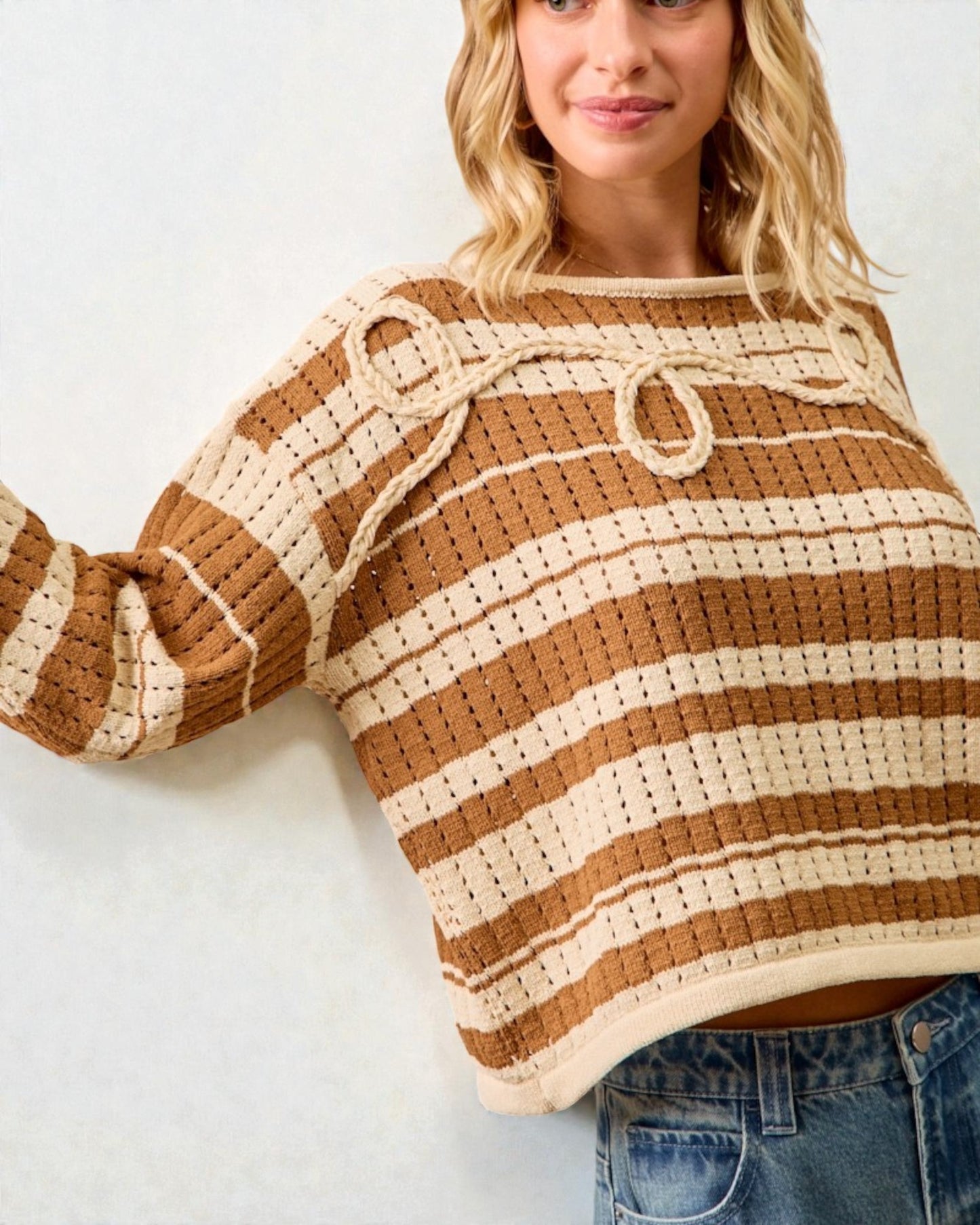 Woman wearing a brown and beige striped sweater against a white background