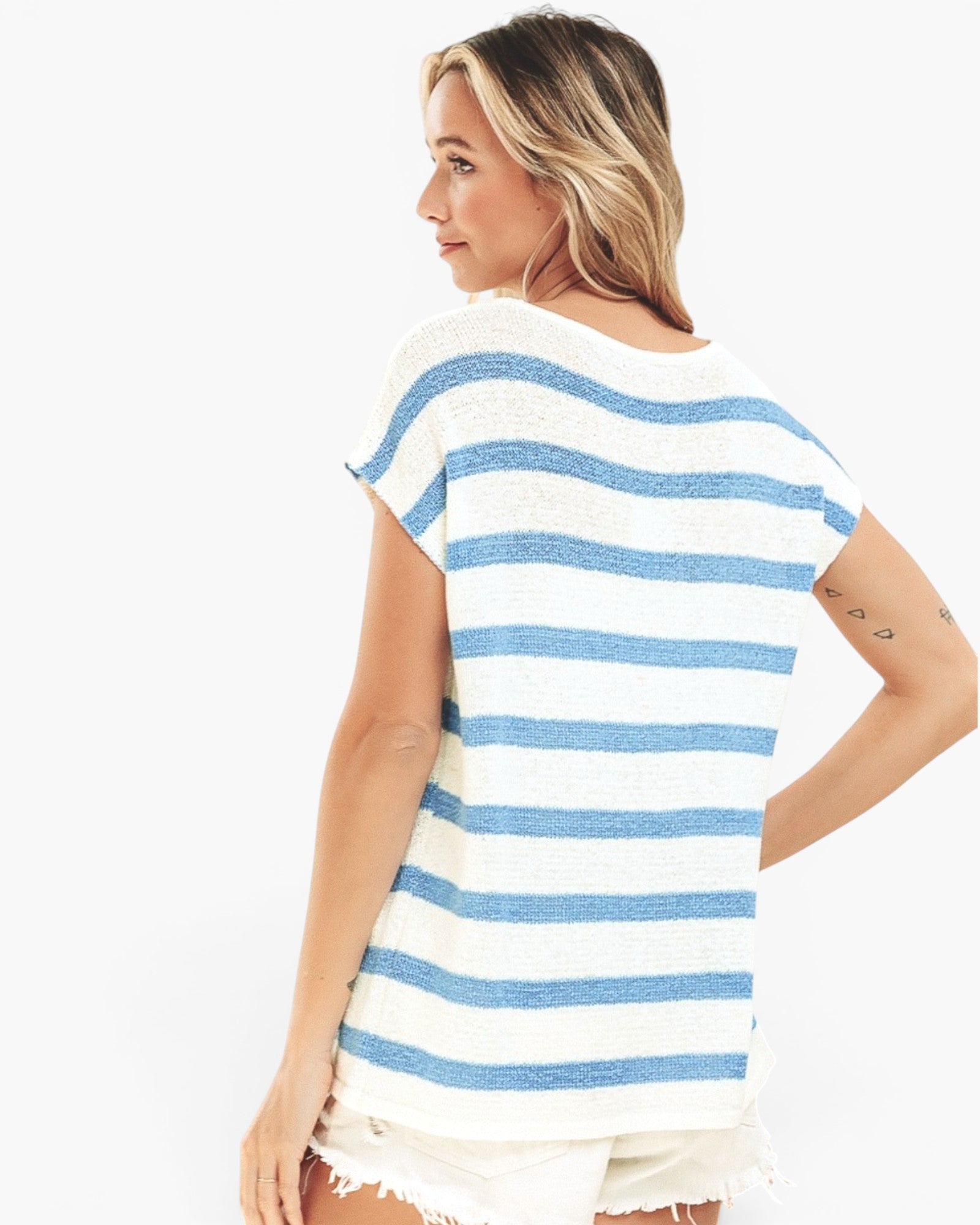A woman wearing a short-sleeve knit top with horizontal blue and white stripes, shown from the back against a plain white background.