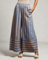 Person wearing blue and beige striped wide-leg pants on a plain background