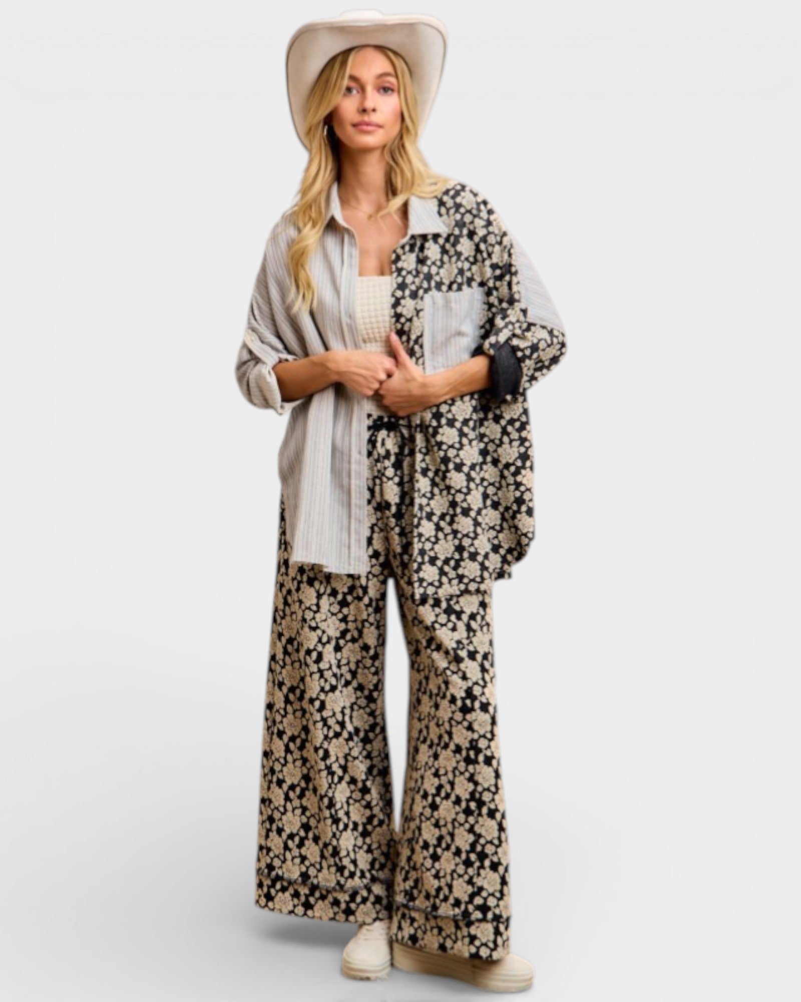 Woman wearing a floral kimono over a white outfit on a light gray background