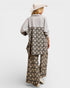 Person wearing a floral dress with a plain shirt underneath on a white background