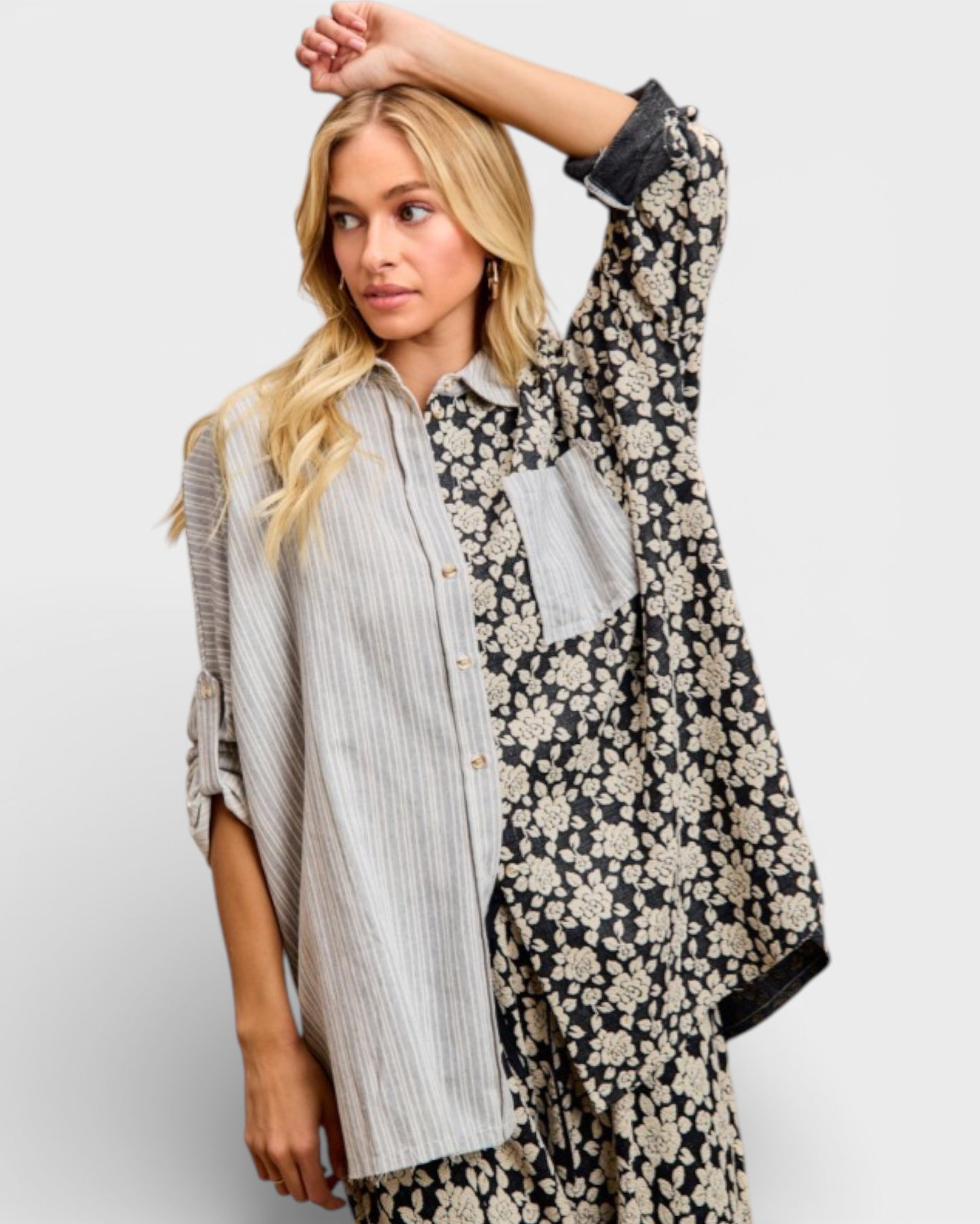 Woman wearing a floral patterned kimono-style garment over a striped shirt on a white background