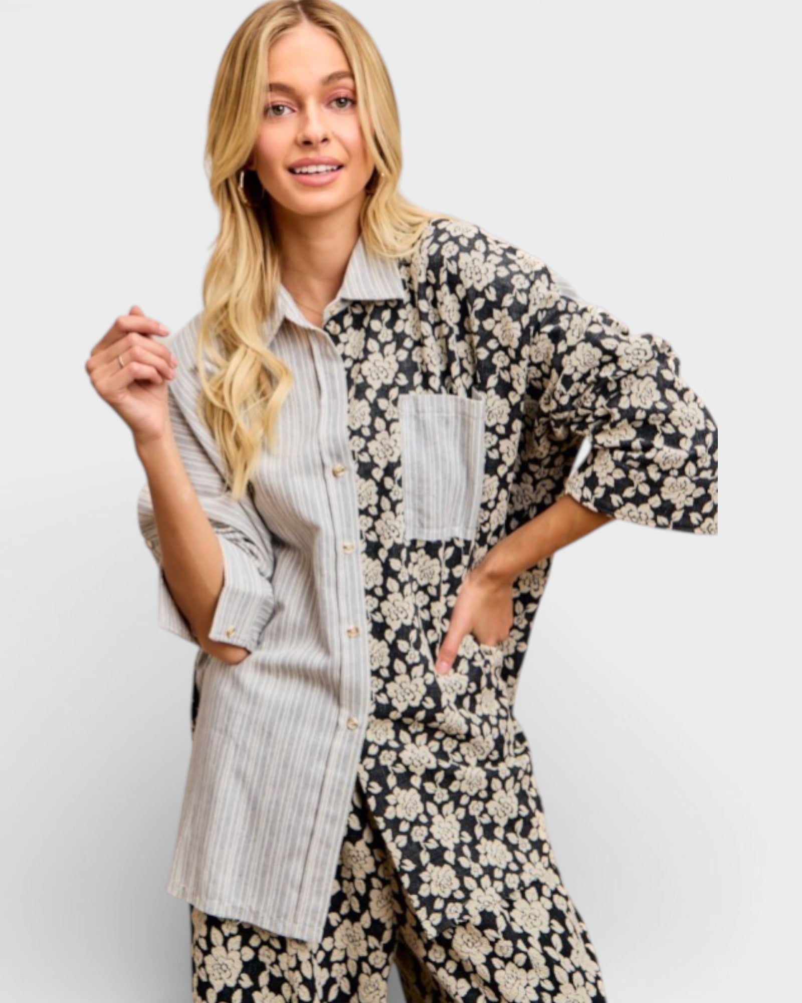 Woman wearing a floral dress over a striped shirt on a white background