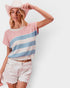 Woman wearing a striped sweater and denim shorts with a white background