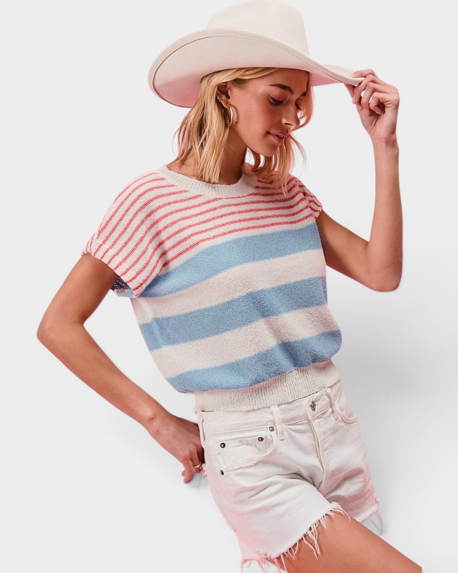 Woman wearing a striped sweater and wide-brimmed hat on a white background