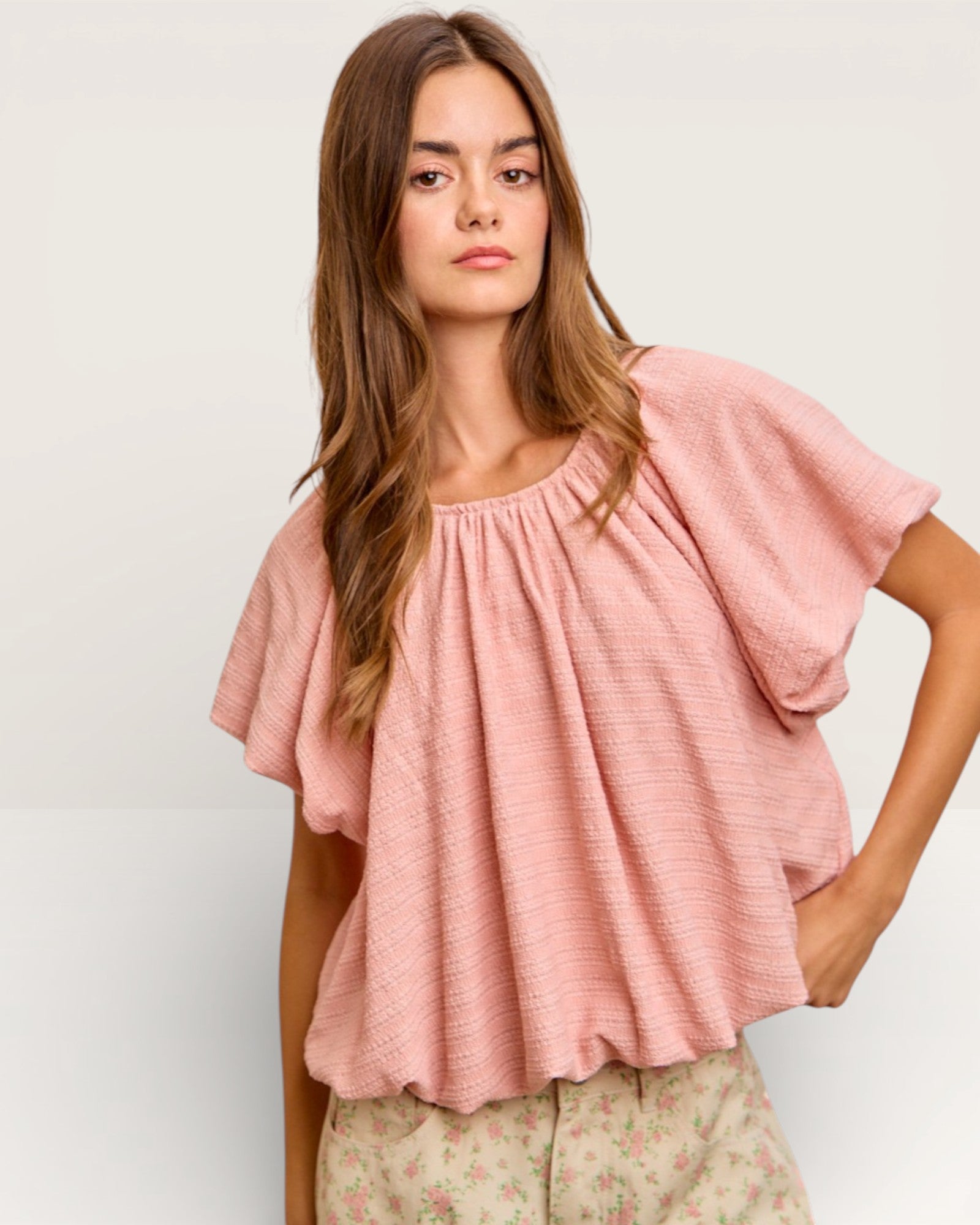 Woman wearing a pink blouse with a plain background