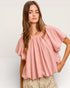Woman wearing a pink blouse with a plain background