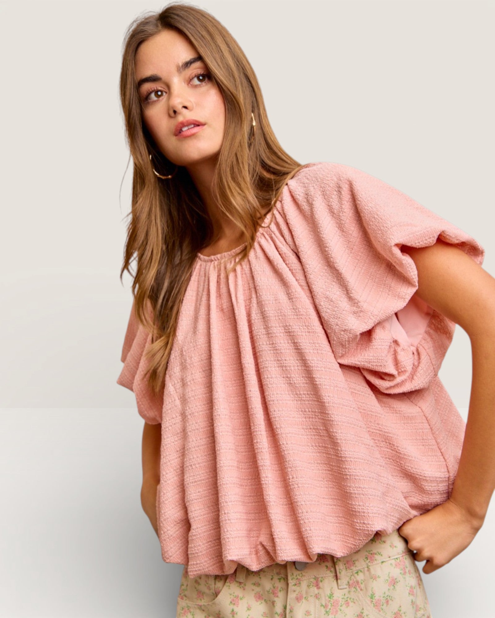 Woman wearing a pink blouse against a plain background