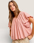 Woman wearing a pink blouse against a plain background