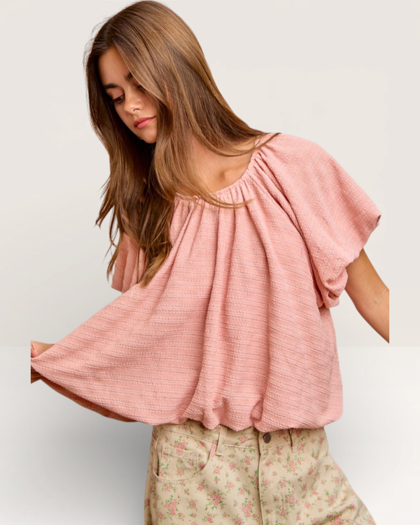 Woman wearing a pink blouse with a plain background