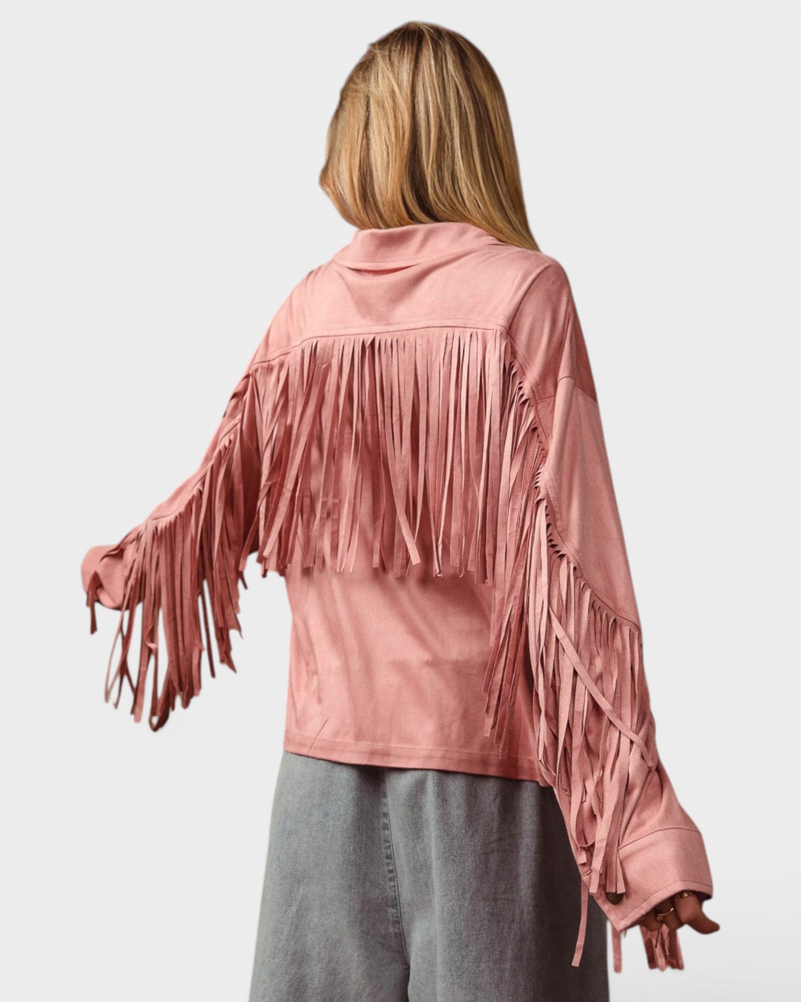 Person wearing a pink fringe jacket on a white background
