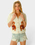 Woman wearing a cream-colored cardigan with teddy bear designs on a white background