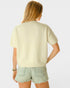 Person wearing a light green sweater and denim shorts on a white background