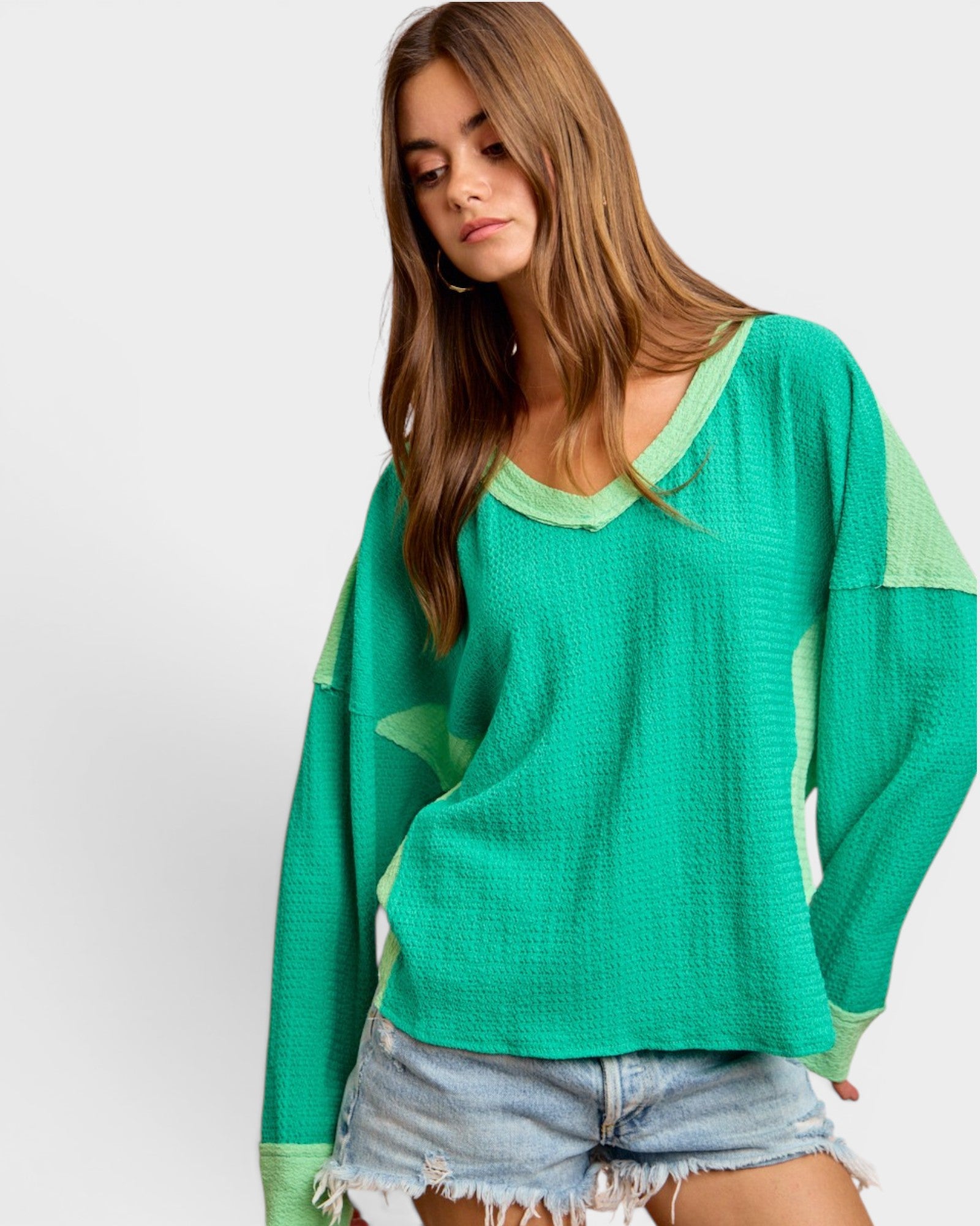 Woman wearing a green sweater with a white background