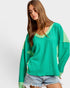 Woman wearing a green sweater with a white background