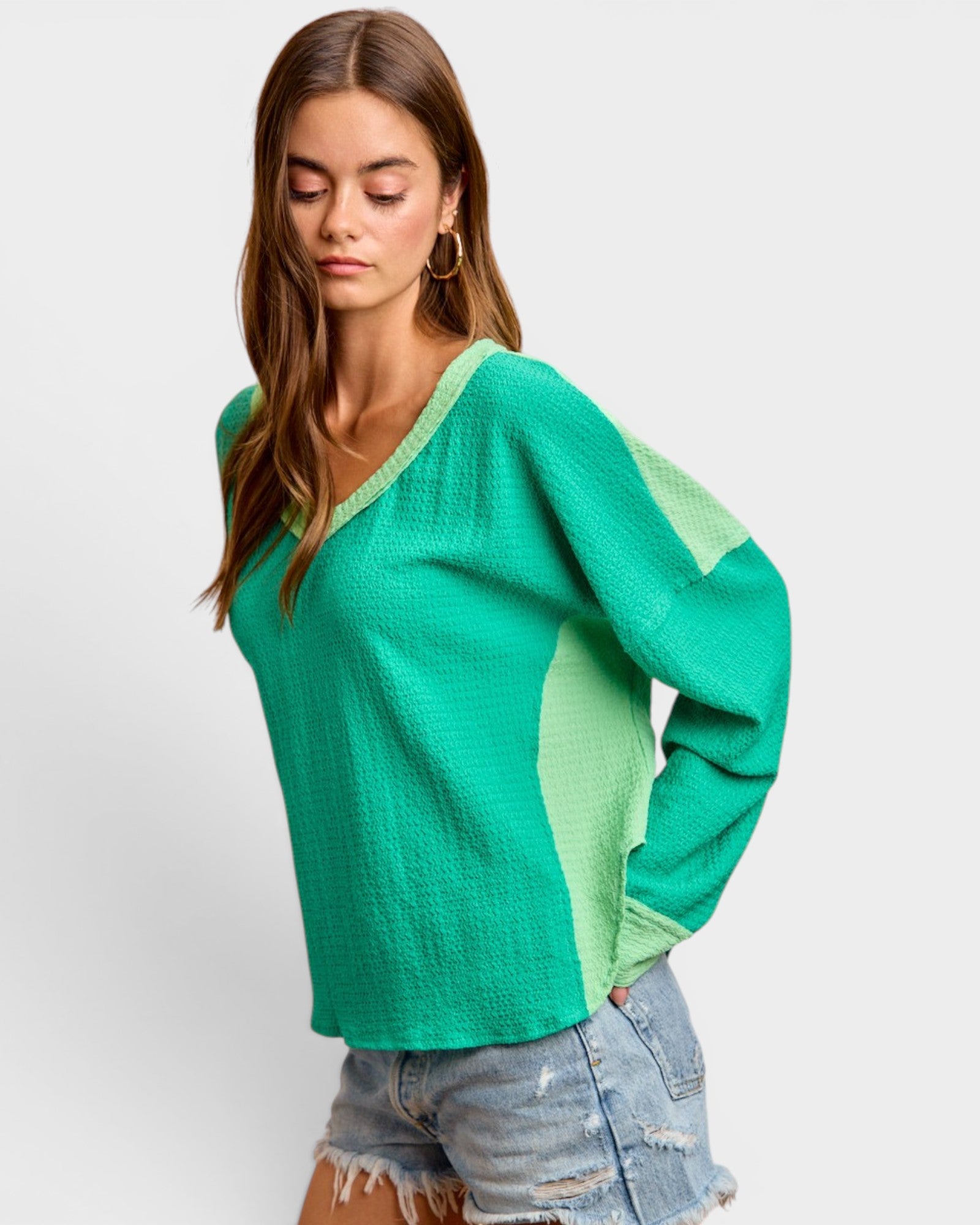 Woman wearing a green sweater with a white background