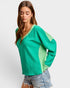 Woman wearing a green sweater with a white background