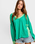 Woman wearing a green long-sleeve top with a white background