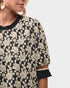 Black sweater with white floral pattern worn by a person