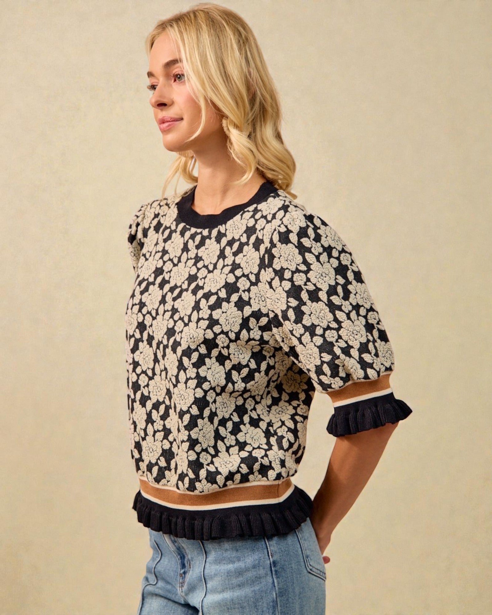 Woman wearing a floral patterned sweater with a beige background