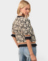 Woman wearing a patterned sweater and jeans on a white background