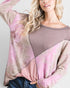 Woman wearing a pink and beige sweater with a textured pattern on a white background