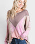 Woman wearing a pink and brown color-blocked sweater on a white background