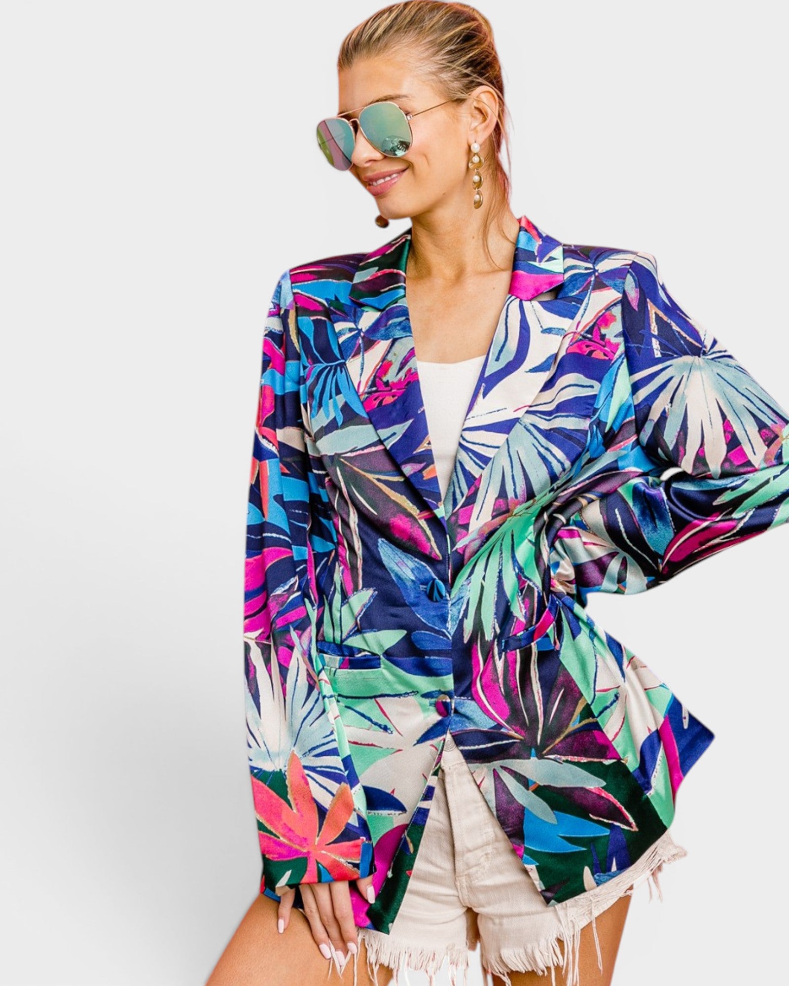 Woman wearing a colorful tropical print jacket on a white background
