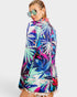 Woman wearing a colorful tropical print shirt on a white background