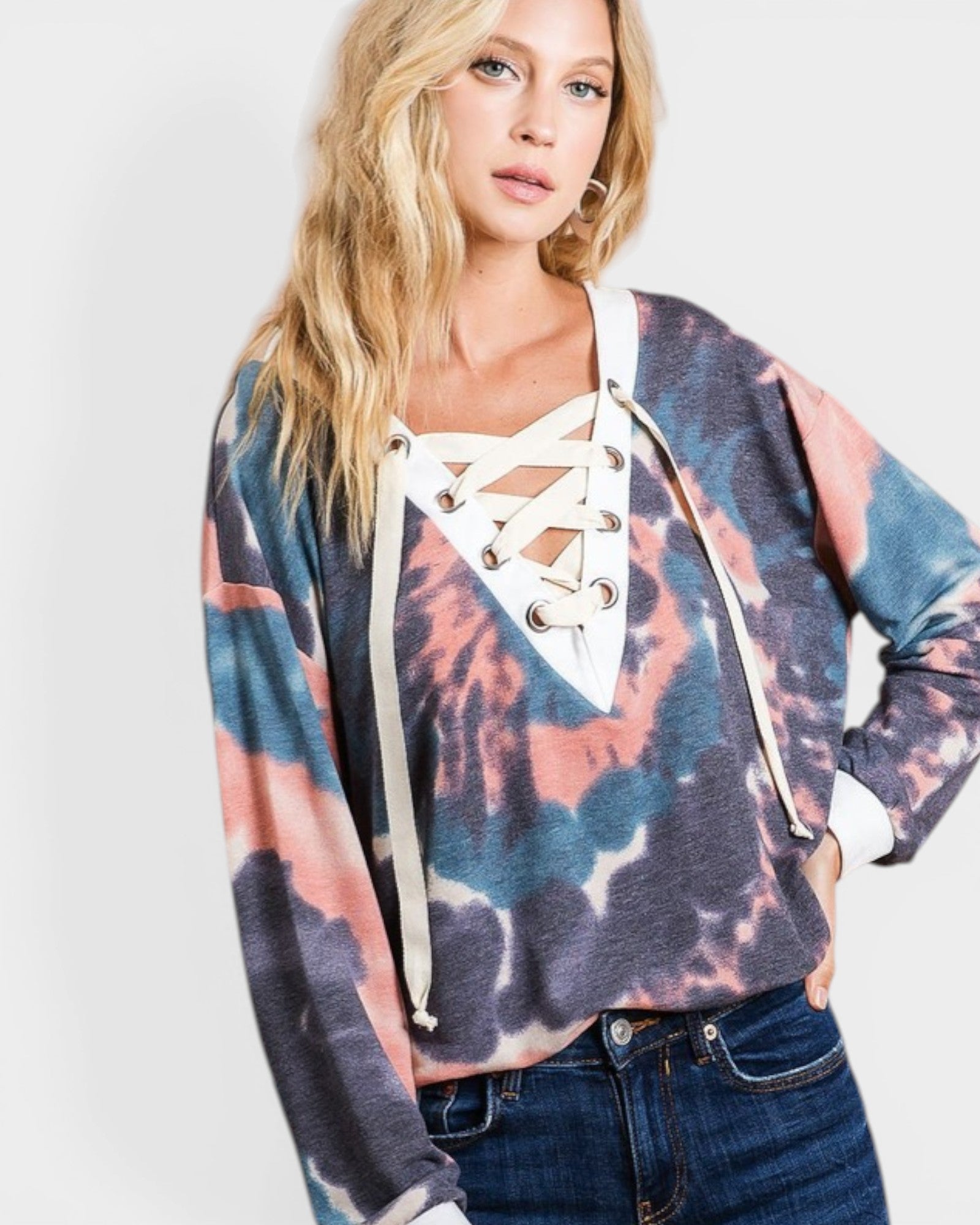 Woman wearing a colorful tie-dye hoodie with lace-up front design on a white background