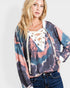 Woman wearing a colorful tie-dye hoodie with lace-up front design on a white background