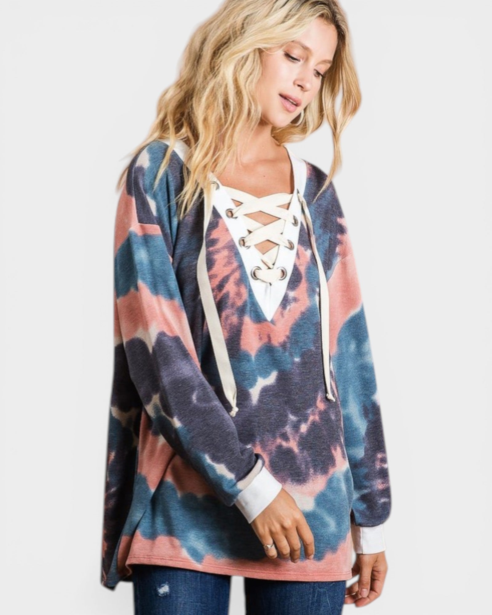 Woman wearing a colorful tie-dye hoodie with lace-up front design on a white background