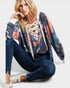 Woman wearing a colorful cardigan, jeans, and sneakers on a white background