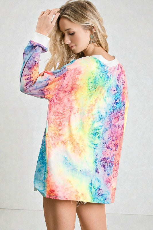 Woman wearing a colorful tie-dye hoodie against a plain background