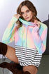 Woman wearing a colorful tie-dye hoodie with a striped skirt and brown boots.