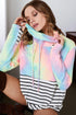 Woman wearing a colorful tie-dye hoodie over a striped shirt.