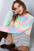Person wearing a colorful hoodie with a neutral background