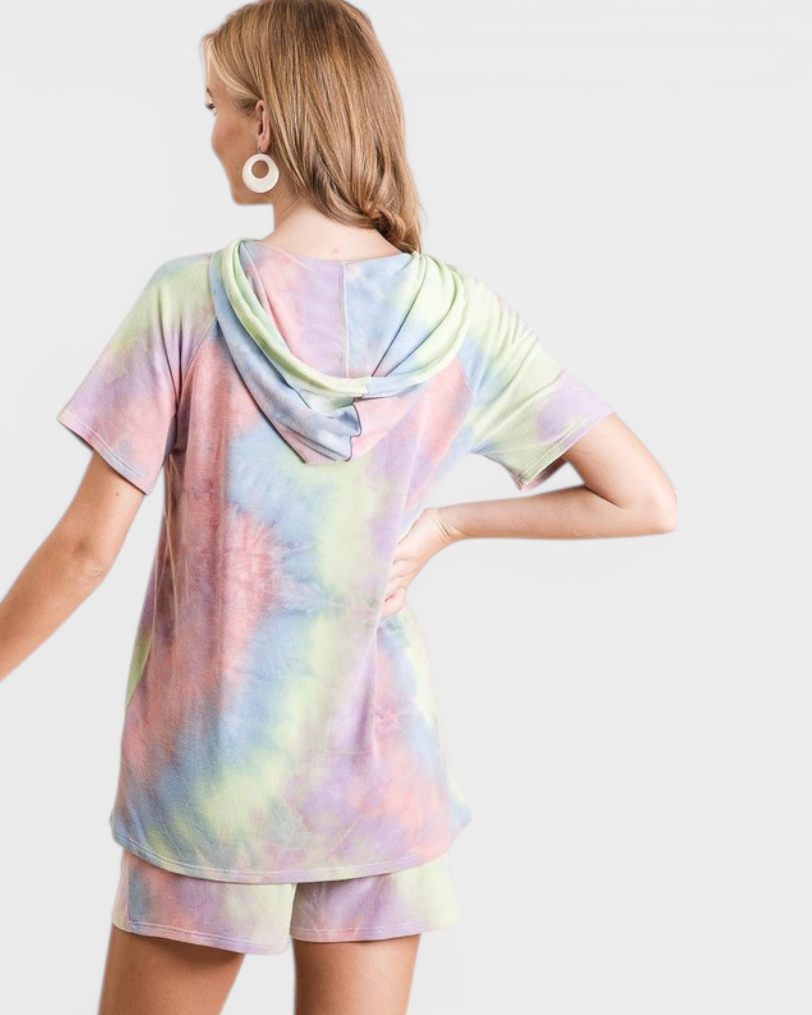 Woman wearing a pastel tie-dye dress on a white background