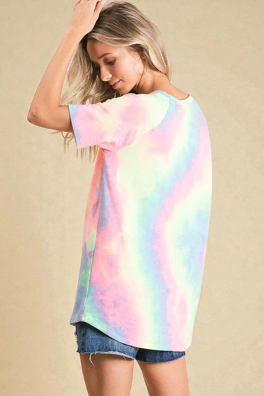 Woman wearing a pastel tie-dye shirt against a beige background