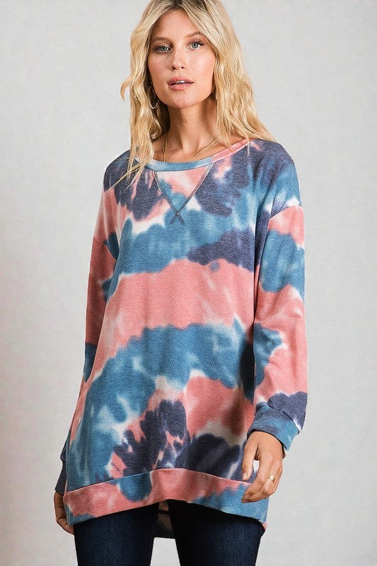 Woman wearing a tie-dye sweater with a neutral background